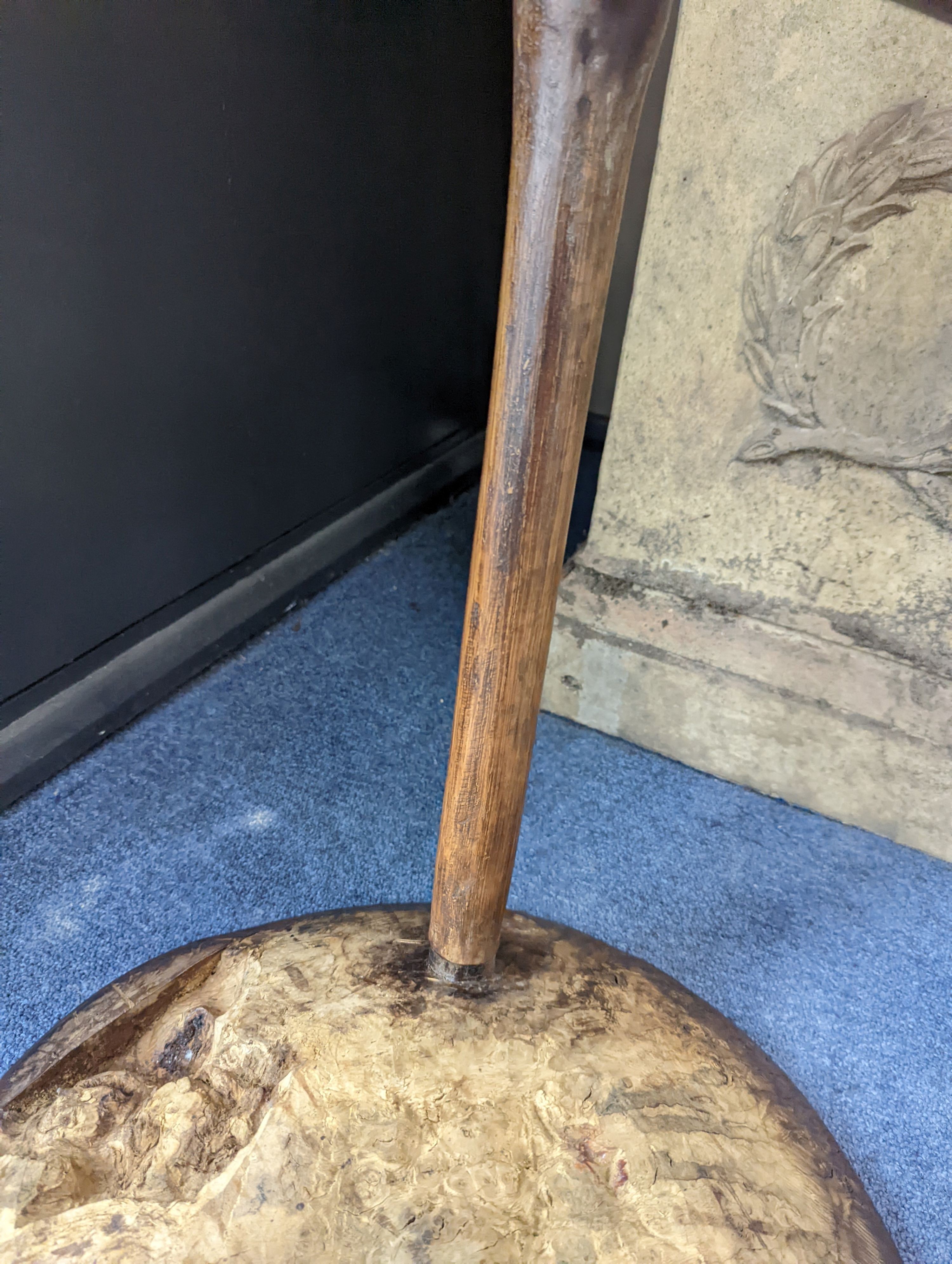 A circular burr elm and ash primitive cricket table with T shaped stretcher, diameter 44cm, height 61cm